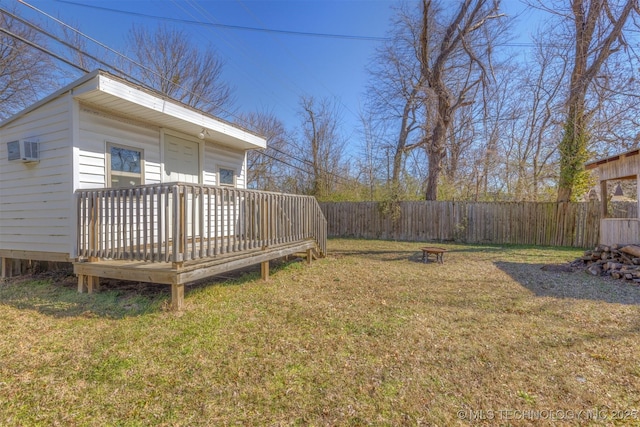 view of yard featuring an AC wall unit, a fenced backyard, and a wooden deck