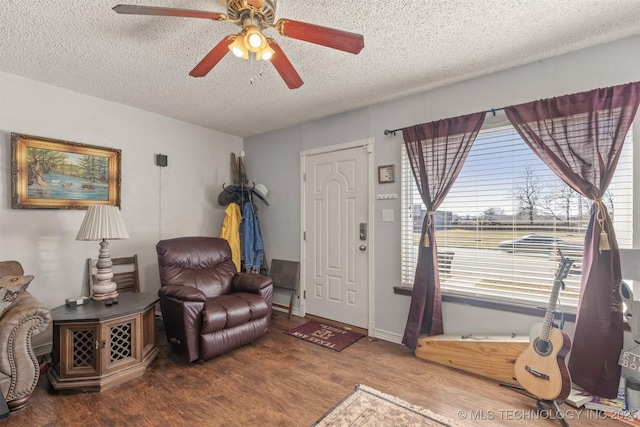 entrance foyer featuring ceiling fan, a textured ceiling, baseboards, and wood finished floors