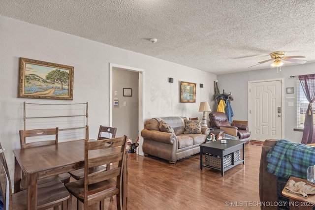 living room featuring a ceiling fan, a textured ceiling, and wood finished floors