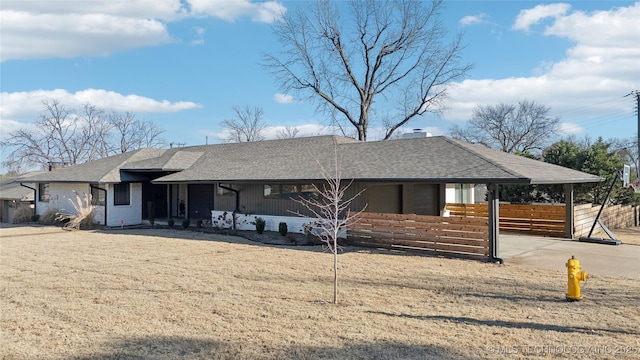 ranch-style house with roof with shingles, a chimney, and fence