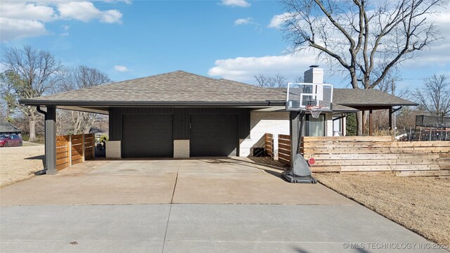 2808 E 37th Pl, Tulsa, OK 74105 - view of side of property with roof with shingles, a chimney, driveway, and brick siding