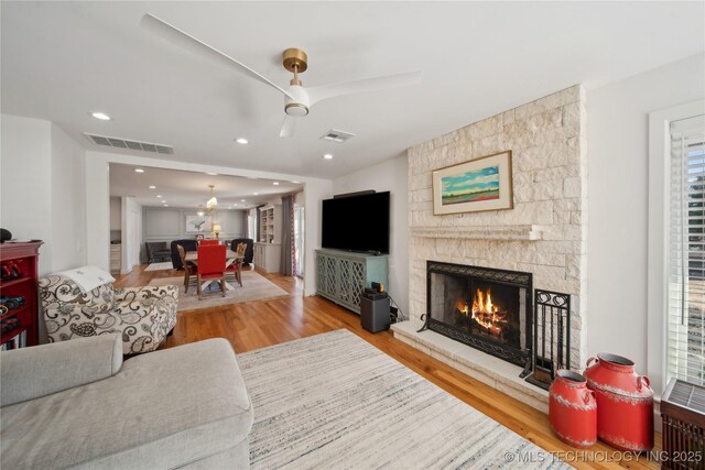 2808 E 37th Pl, Tulsa, OK 74105 - living area featuring wood finished floors, a stone fireplace, ceiling fan, and recessed lighting