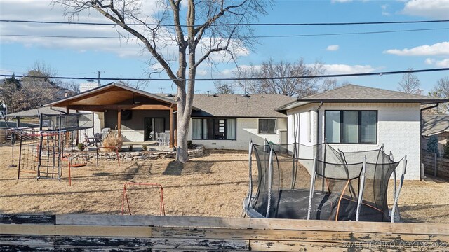 2808 E 37th Pl, Tulsa, OK 74105 - view of front of home with a trampoline, brick siding, and a shingled roof