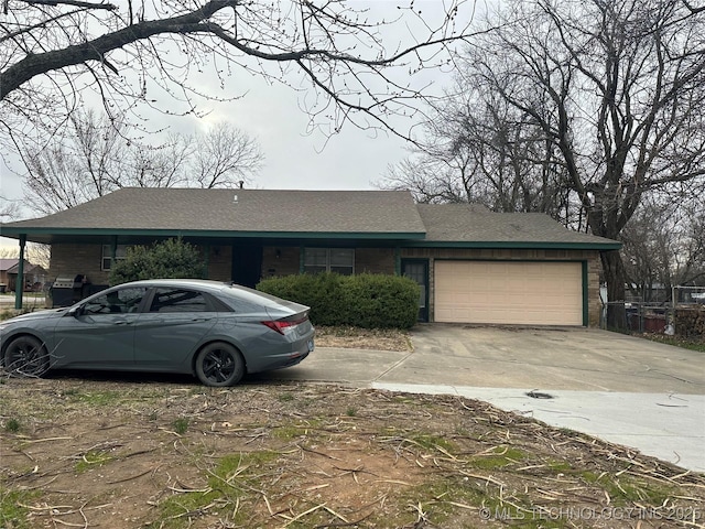 ranch-style home with a garage, brick siding, and driveway