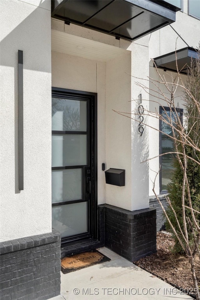 property entrance with stucco siding