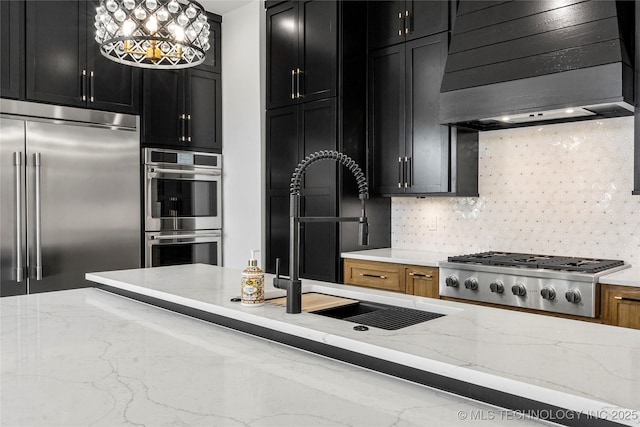 kitchen featuring tasteful backsplash, dark cabinets, ventilation hood, stainless steel appliances, and a sink