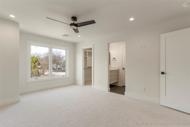 unfurnished bedroom featuring recessed lighting, carpet flooring, visible vents, baseboards, and a walk in closet