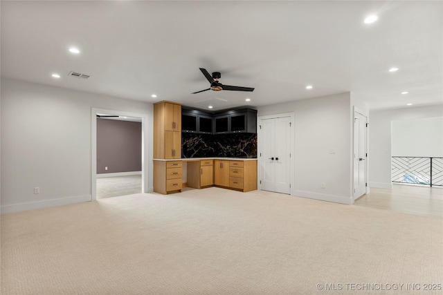 unfurnished living room with light carpet, recessed lighting, visible vents, and built in study area