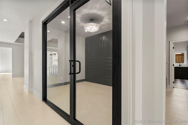 hall with recessed lighting, a sink, and an inviting chandelier