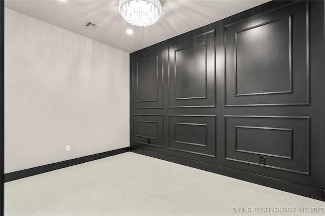 unfurnished bedroom featuring baseboards, visible vents, and a notable chandelier