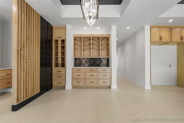 spacious closet with a chandelier and a tray ceiling