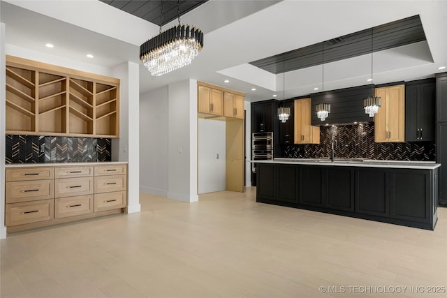 kitchen with recessed lighting, light countertops, backsplash, light brown cabinetry, and an inviting chandelier