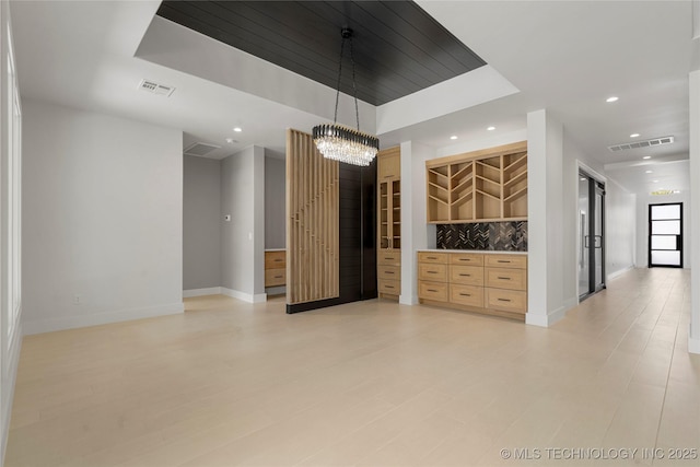 spare room with baseboards, visible vents, a raised ceiling, and recessed lighting