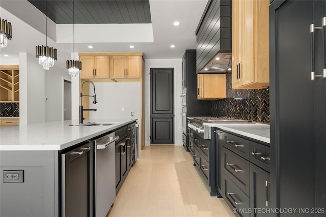 kitchen featuring a center island with sink, a raised ceiling, custom exhaust hood, light brown cabinets, and a sink