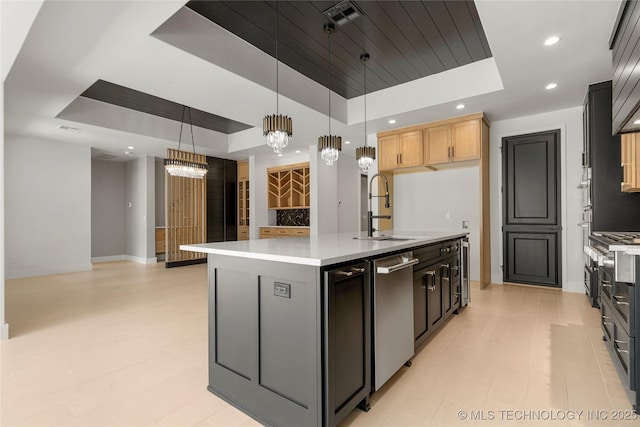 kitchen with a raised ceiling, a sink, and light countertops