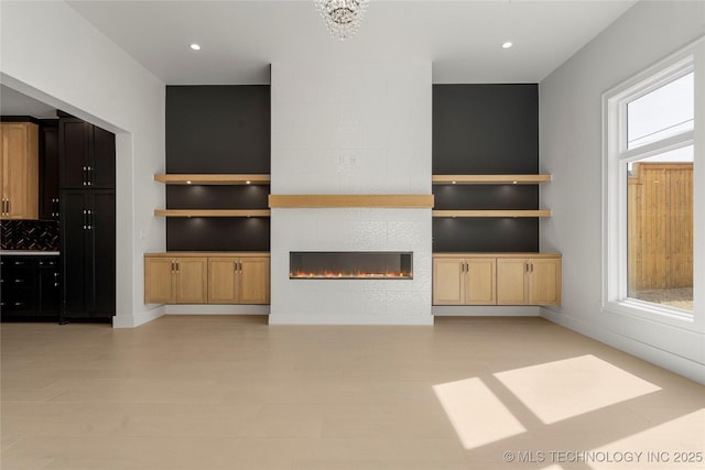 unfurnished living room with built in shelves, a fireplace, and recessed lighting