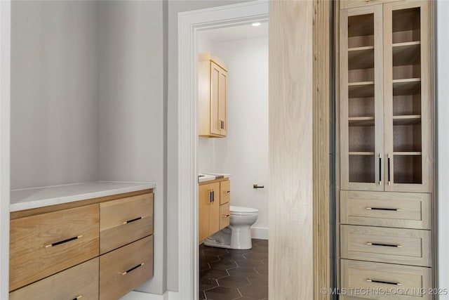 bathroom with toilet, tile patterned floors, and vanity