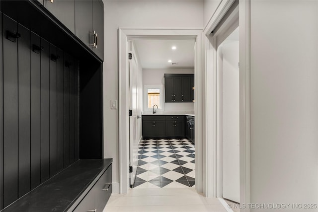 mudroom featuring light floors, a sink, and recessed lighting