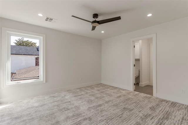 carpeted empty room featuring a ceiling fan, visible vents, and recessed lighting