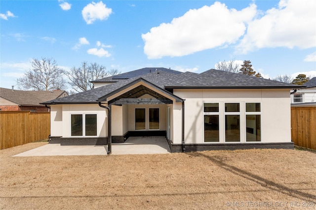 back of property featuring brick siding, a patio area, and a fenced backyard