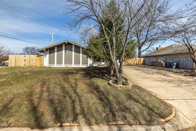 view of yard featuring fence and driveway