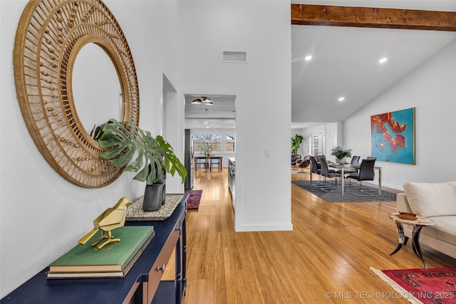 hall with wood finished floors, baseboards, visible vents, high vaulted ceiling, and beam ceiling