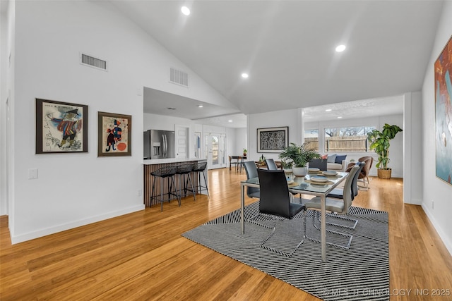 dining space with recessed lighting, light wood-style floors, visible vents, and high vaulted ceiling