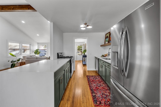 kitchen with green cabinetry, open shelves, light wood-style flooring, stainless steel appliances, and light countertops