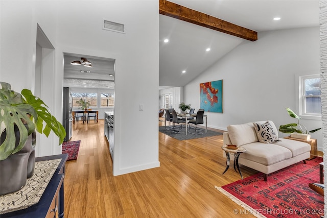 living area featuring visible vents, vaulted ceiling with beams, baseboards, light wood-type flooring, and recessed lighting