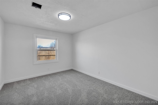 unfurnished room featuring carpet, baseboards, and a textured ceiling