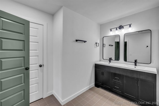 full bath featuring double vanity, baseboards, and a sink