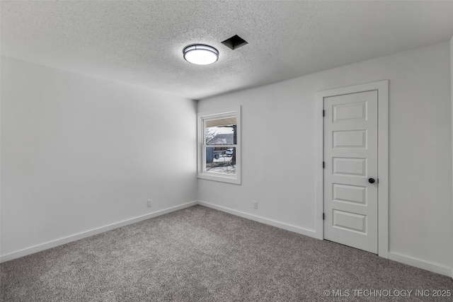 spare room with baseboards, a textured ceiling, and carpet flooring