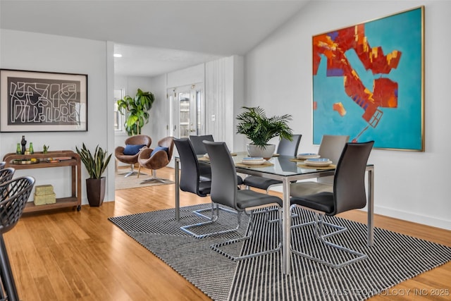 dining space with baseboards and wood finished floors