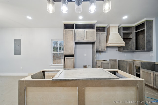 kitchen with custom range hood, electric panel, a center island, recessed lighting, and baseboards