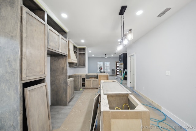 kitchen with visible vents, a ceiling fan, a center island, recessed lighting, and concrete floors