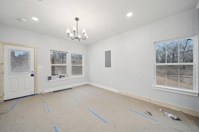 unfurnished dining area with electric panel, recessed lighting, a wealth of natural light, and a chandelier