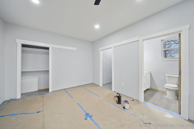 unfurnished bedroom featuring ensuite bathroom, recessed lighting, and two closets