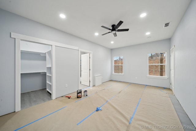 unfurnished bedroom with a spacious closet, visible vents, recessed lighting, and a ceiling fan