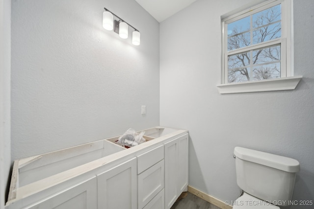 bathroom featuring toilet and baseboards