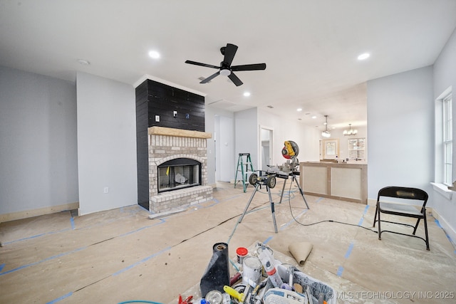 living area with recessed lighting, a fireplace, a ceiling fan, and baseboards