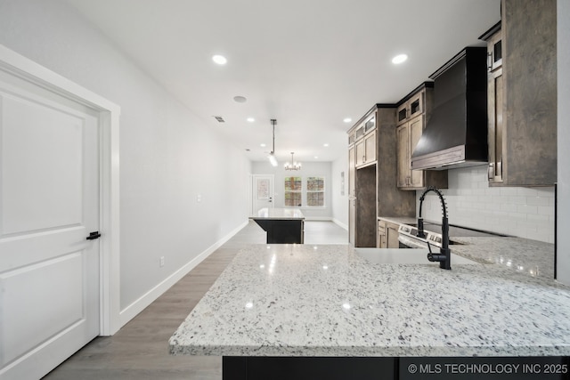 7890 N Oak Dr, Beggs, OK 74421 - kitchen featuring backsplash, light wood-style floors, recessed lighting, and wall chimney exhaust hood