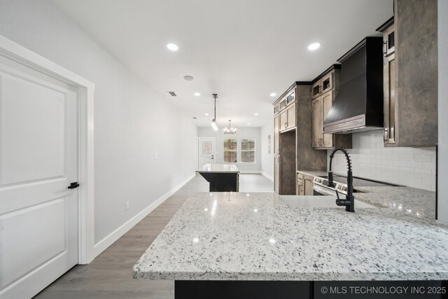 7890 N Oak Dr, Beggs, OK 74421 - kitchen featuring backsplash, light wood-style floors, recessed lighting, and wall chimney exhaust hood