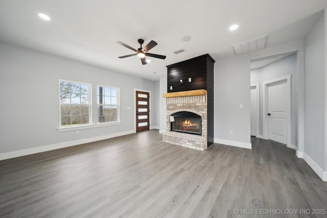 7890 N Oak Dr, Beggs, OK 74421 - unfurnished living room featuring a fireplace, ceiling fan, visible vents, and wood finished floors