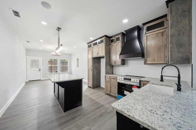 7890 N Oak Dr, Beggs, OK 74421 - kitchen featuring a sink, light wood finished floors, backsplash, stainless steel electric range oven, and custom range hood