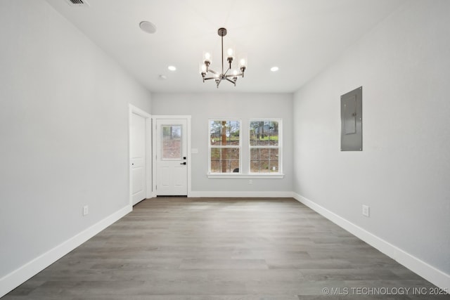 7890 N Oak Dr, Beggs, OK 74421 - unfurnished dining area featuring recessed lighting, baseboards, an inviting chandelier, electric panel, and wood finished floors