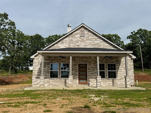 7890 N Oak Dr, Beggs, OK 74421 - view of front facade featuring a chimney, brick siding, and ceiling fan