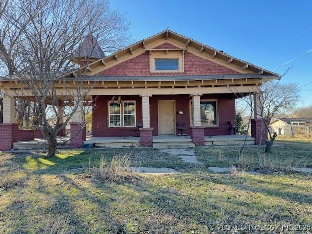 view of front of house featuring a front yard and covered porch