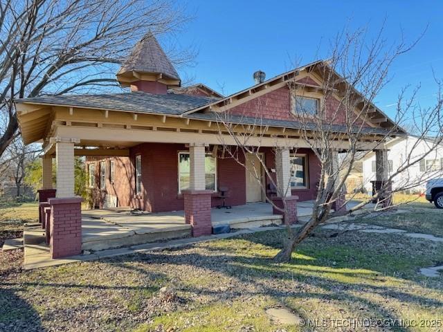 view of front of home with a porch and a front lawn