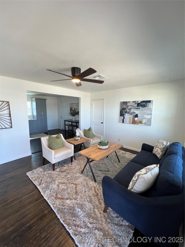 living room with ceiling fan, dark wood finished floors, visible vents, and baseboards