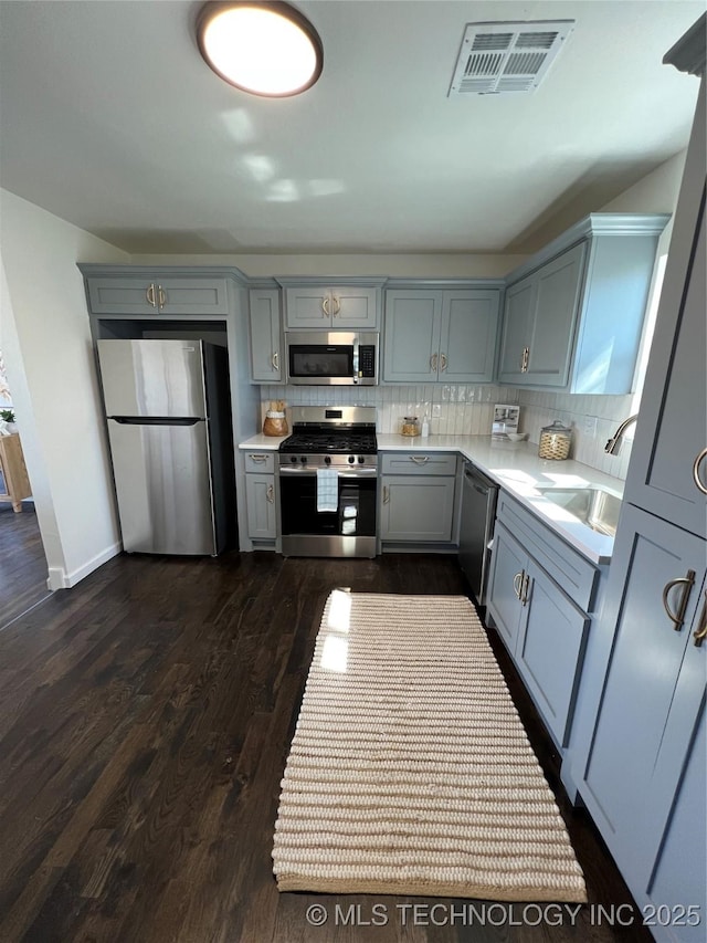 kitchen with visible vents, stainless steel appliances, a sink, and gray cabinetry